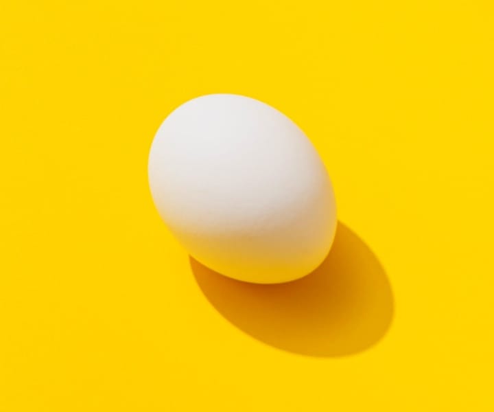 egg casting shadowon yellow background